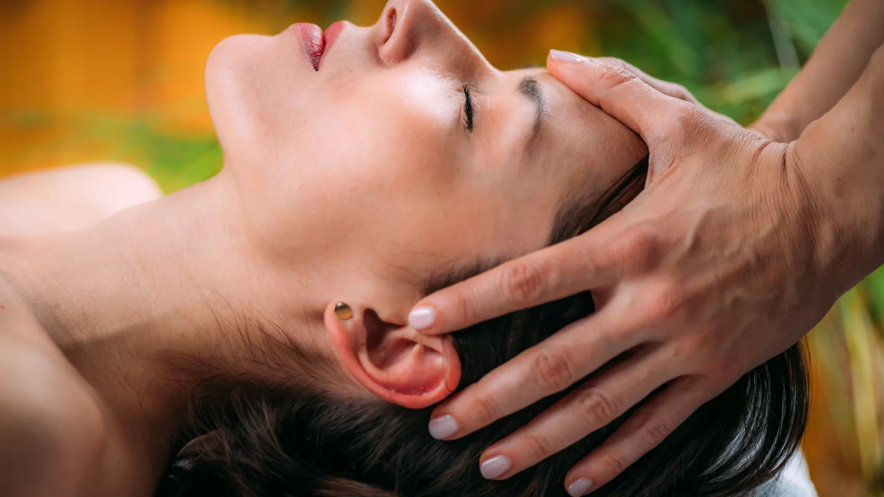 Close-up of woman receiving gentle scalp massage during a calming wellness spa treatment session