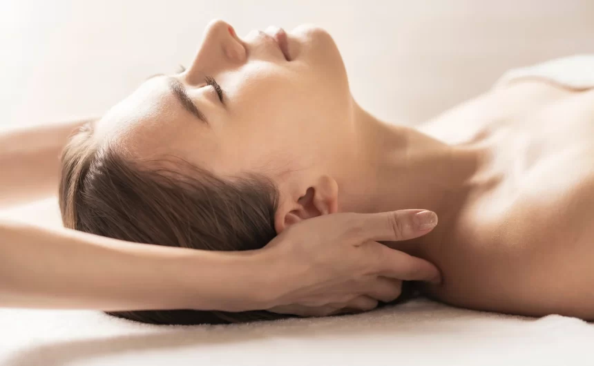 Woman receiving gentle neck massage while resting peacefully during a spa wellness session
