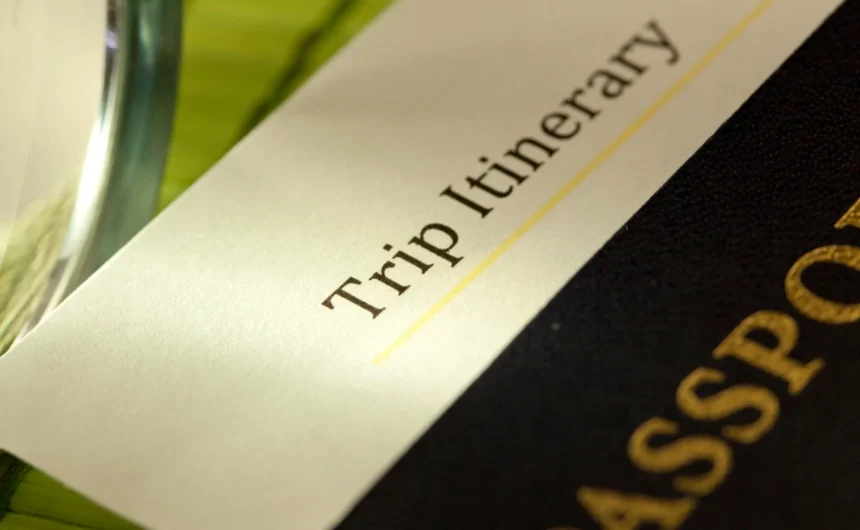 Close-up of a trip itinerary beside a passport, suggesting a relaxing wellness spa getaway or travel retreat.