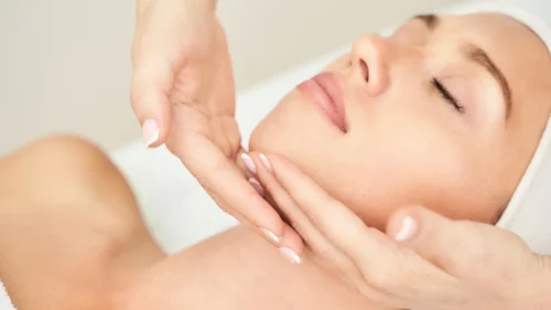 Close-up of a woman receiving a gentle facial massage during a relaxing professional spa treatment session.