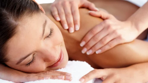 Close-up of a woman receiving a relaxing shoulder and upper back massage during calming spa session.
